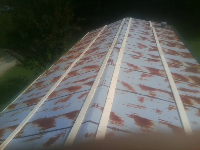 Rusted metal roof panels with new wood purlins before replacement — Storm Damage Roof Repair in Sand Lake by Roofing Brothers